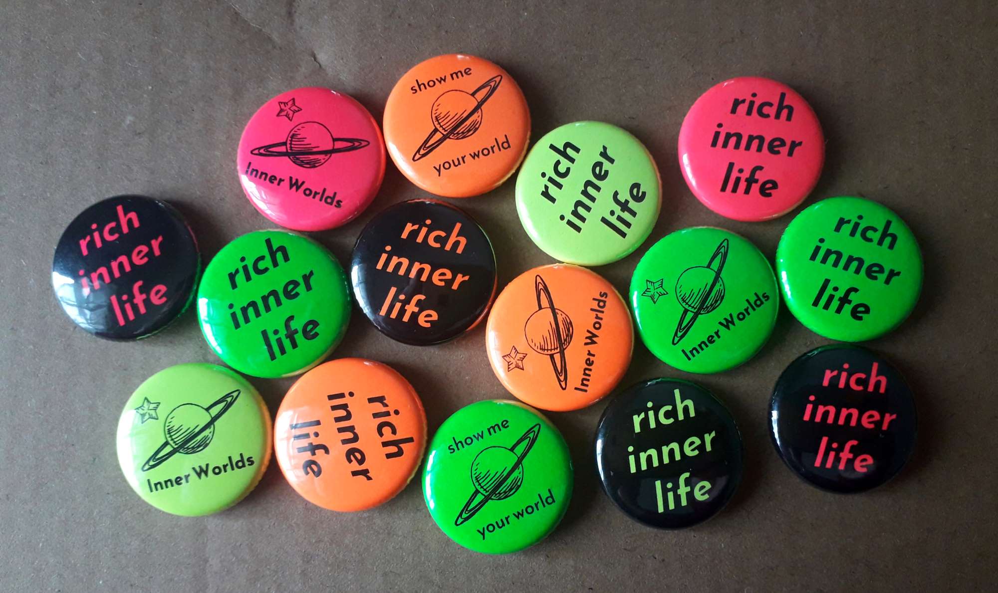 Round button badges in neon colours reading "rich inner life", "show me your world", and the Inner Worlds planet logo